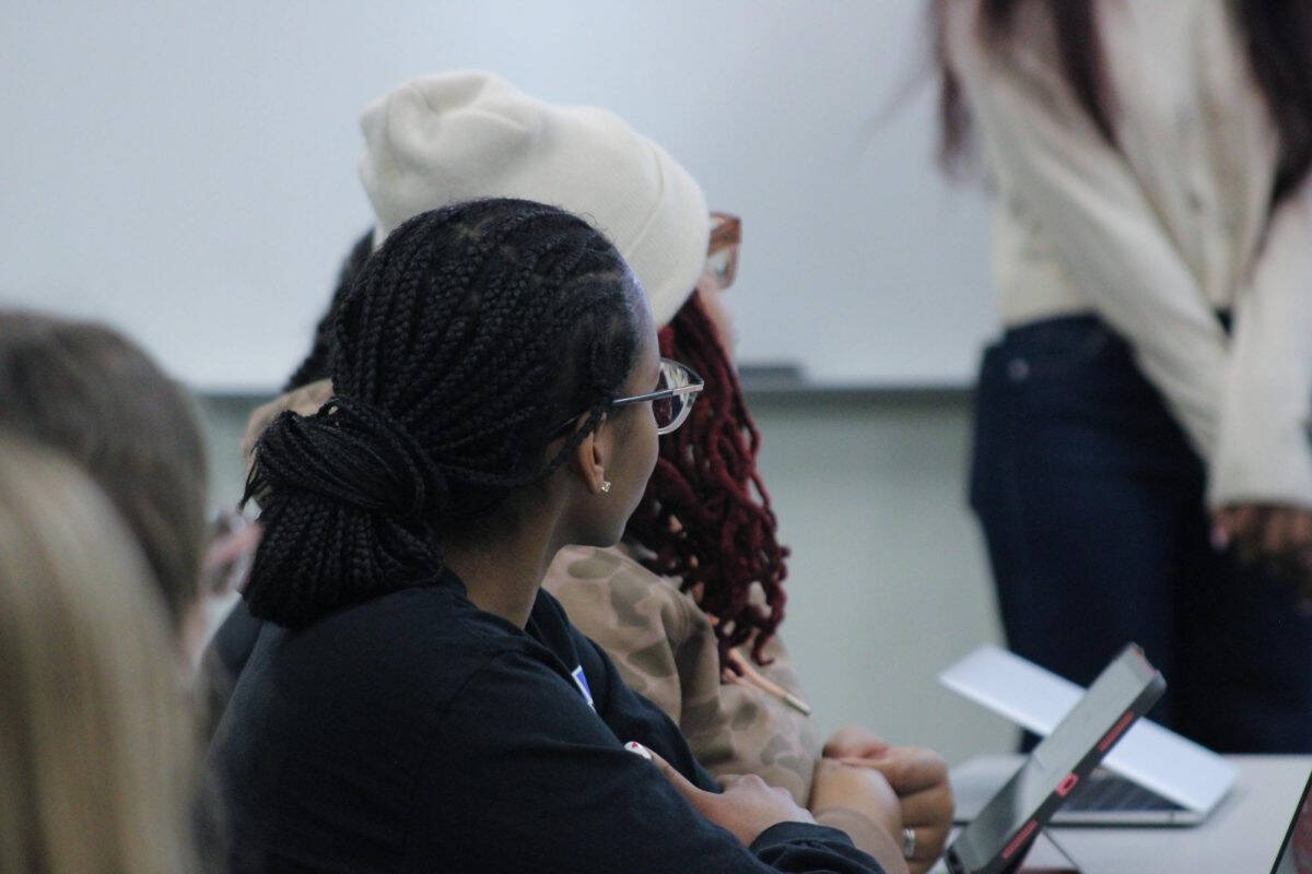 Two students sitting at a table and facing the front of the room